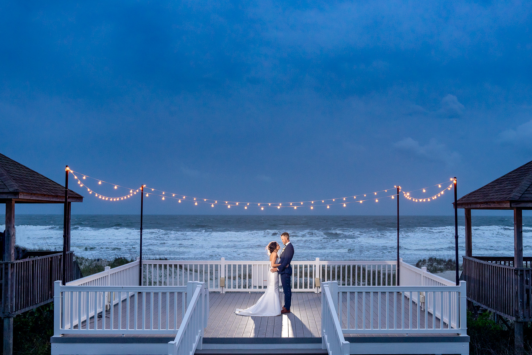 Image of beach house wedding - Bride and groom first dance -  Sunset - Twilight - North Carolina Beach Wedding Photographers - Beach Wedding Photography - Chris Lang Photography