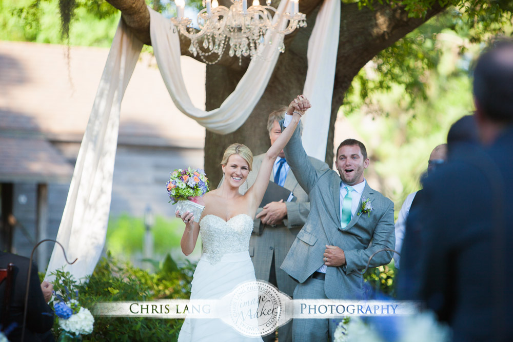 Bride and groom walking down isle at outdoor garden wedding